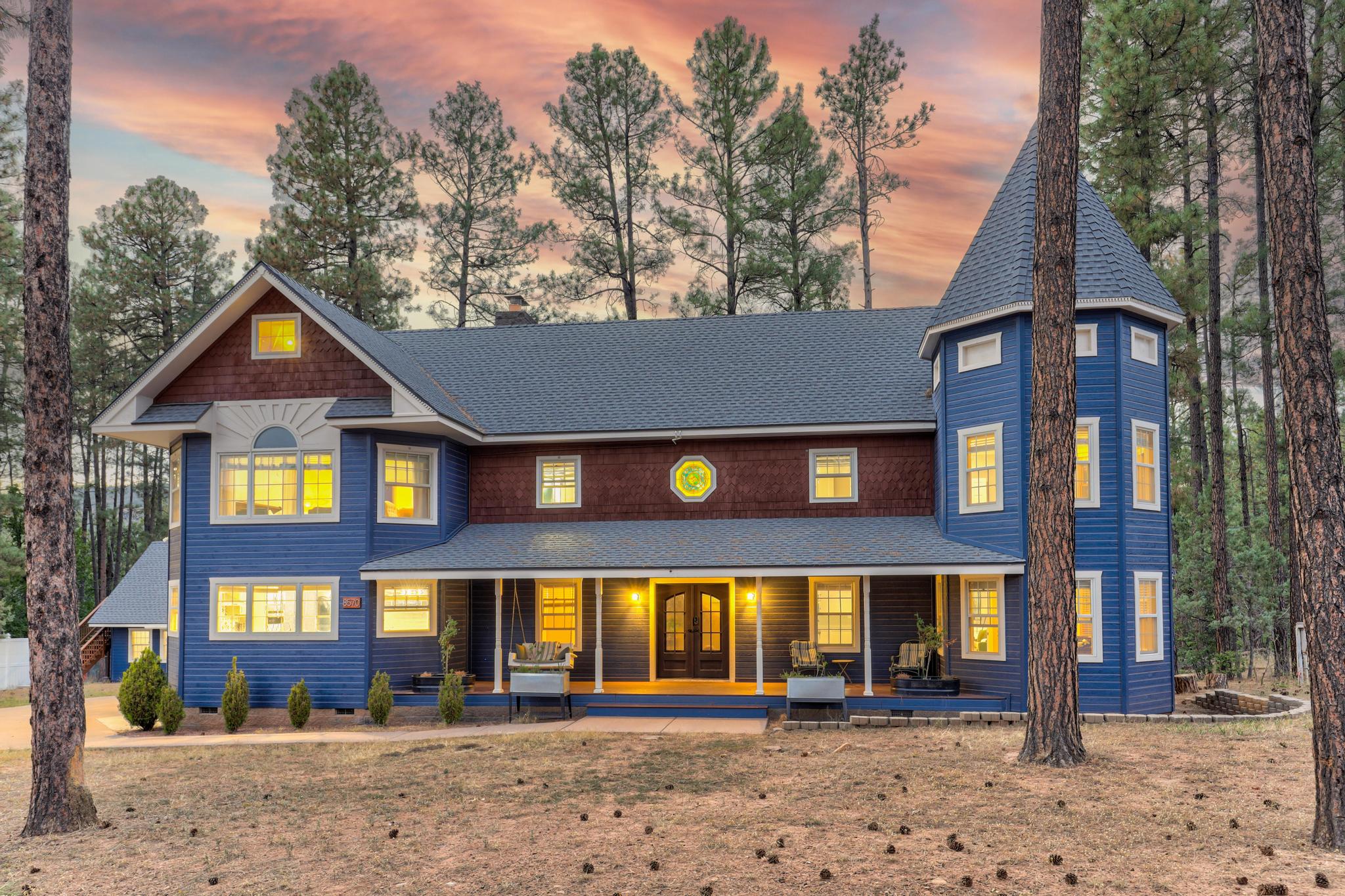 Twilight exterior side view with screened porch and detached game building