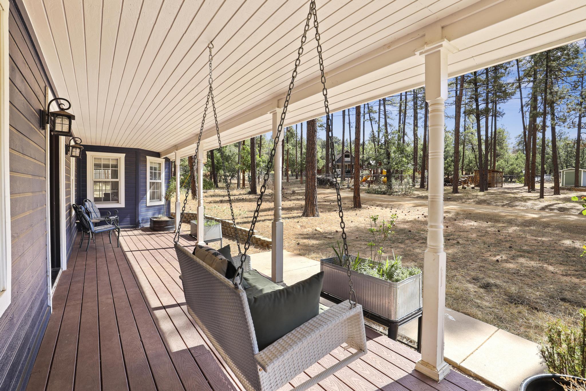 Front porch with swing seating and pine views