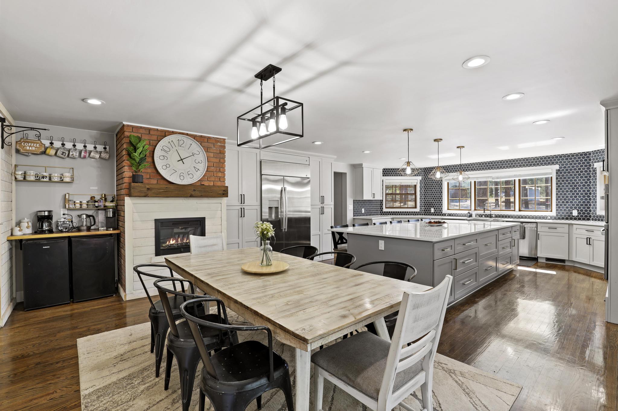 Open kitchen and dining space with large island, dining table, and hearth