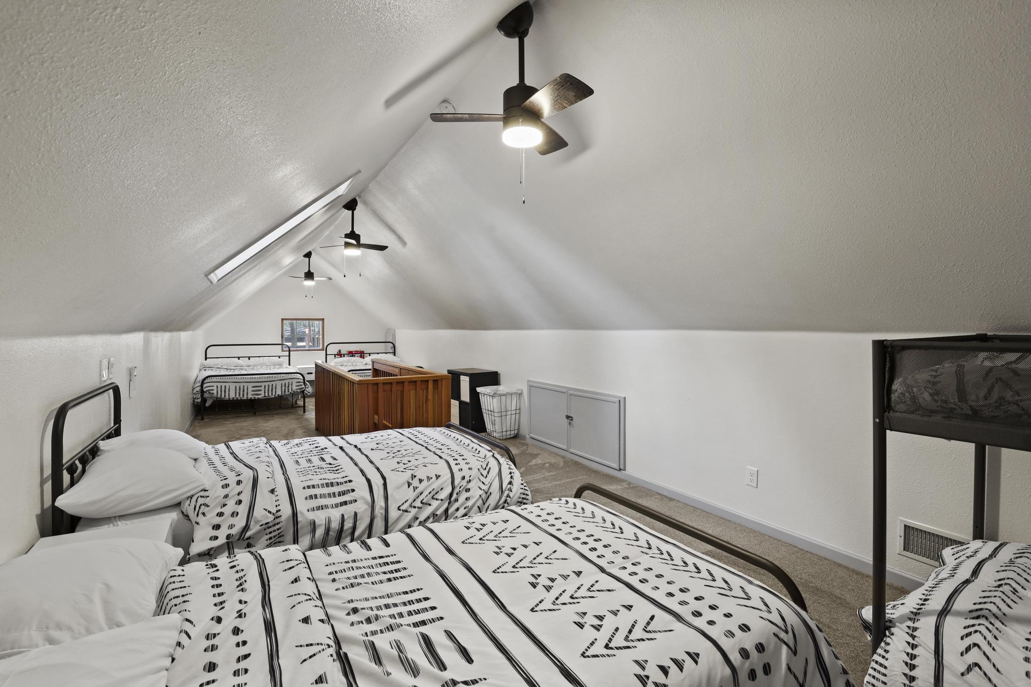 Loft sleeping area with multiple beds and vaulted ceilings