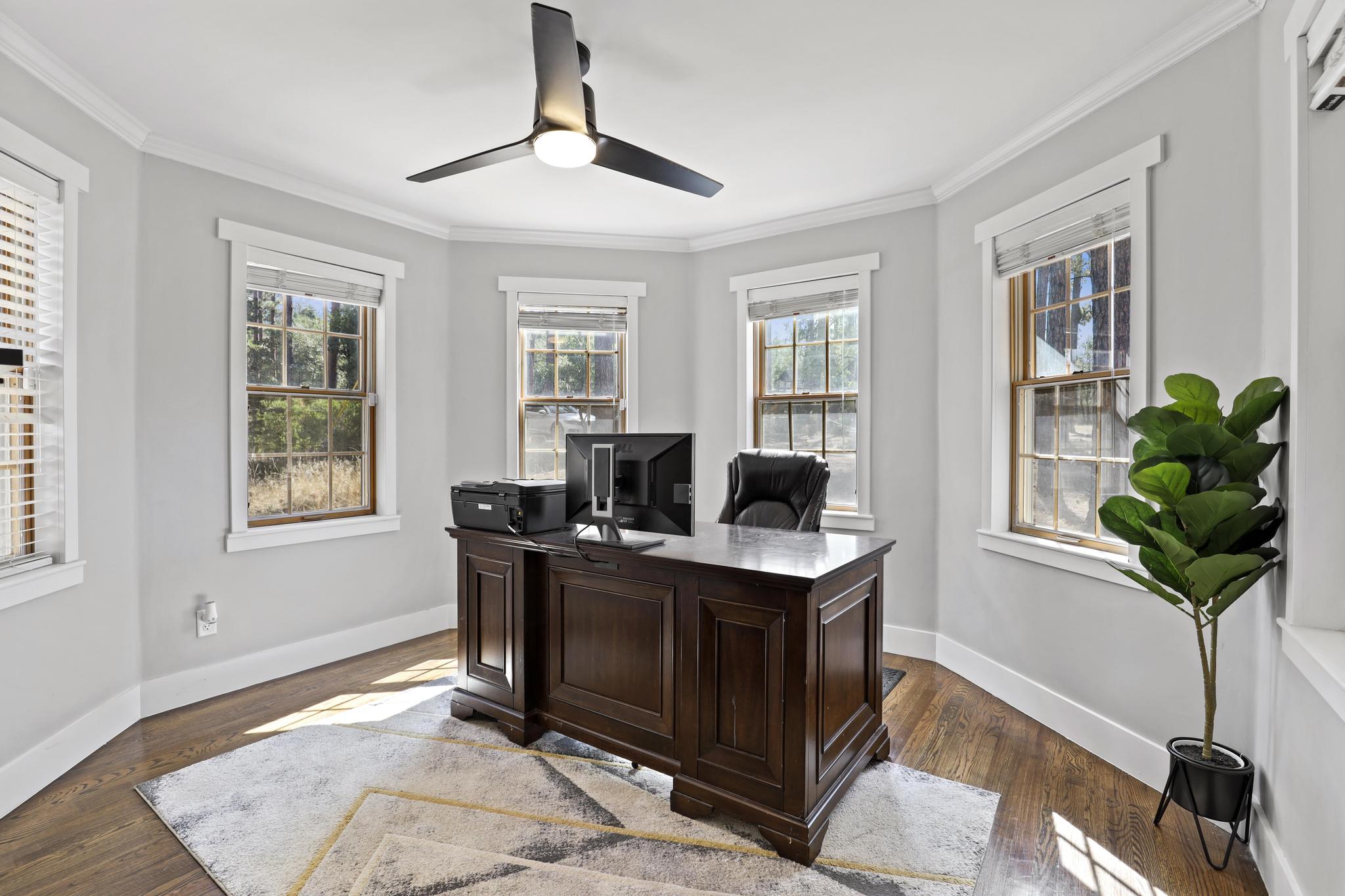 Dedicated office with executive desk and windows on multiple sides