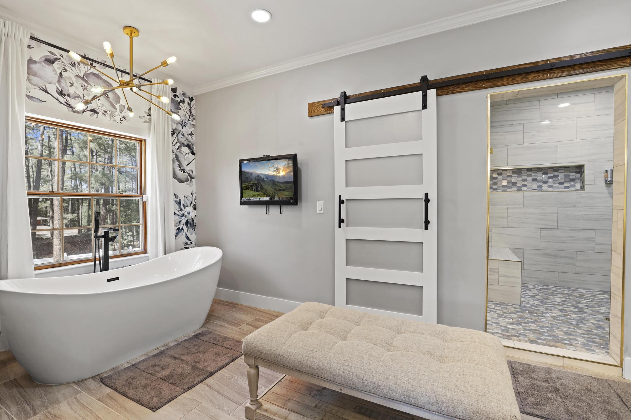 Primary bath with freestanding soaking tub and large tiled shower